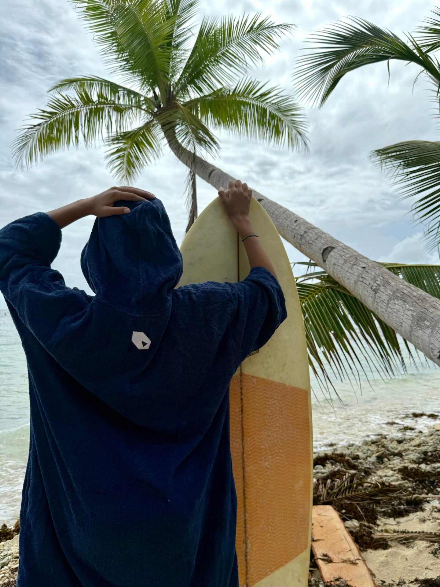 Kvinde i SURFMORE Ocean Badeponcho med surfboard