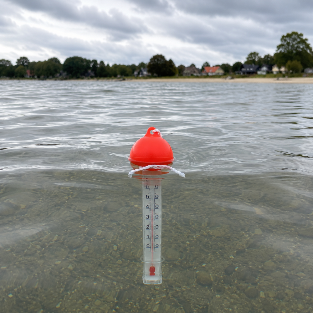 Badevandstermometer med flydende orange bold flyder i vandet