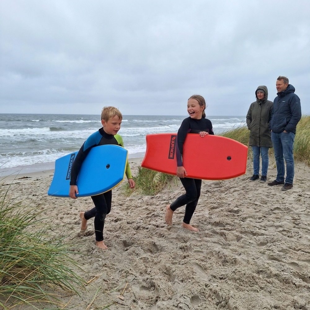 Børn med SURFMORE Ride Bodyboard i blå og rød på stranden